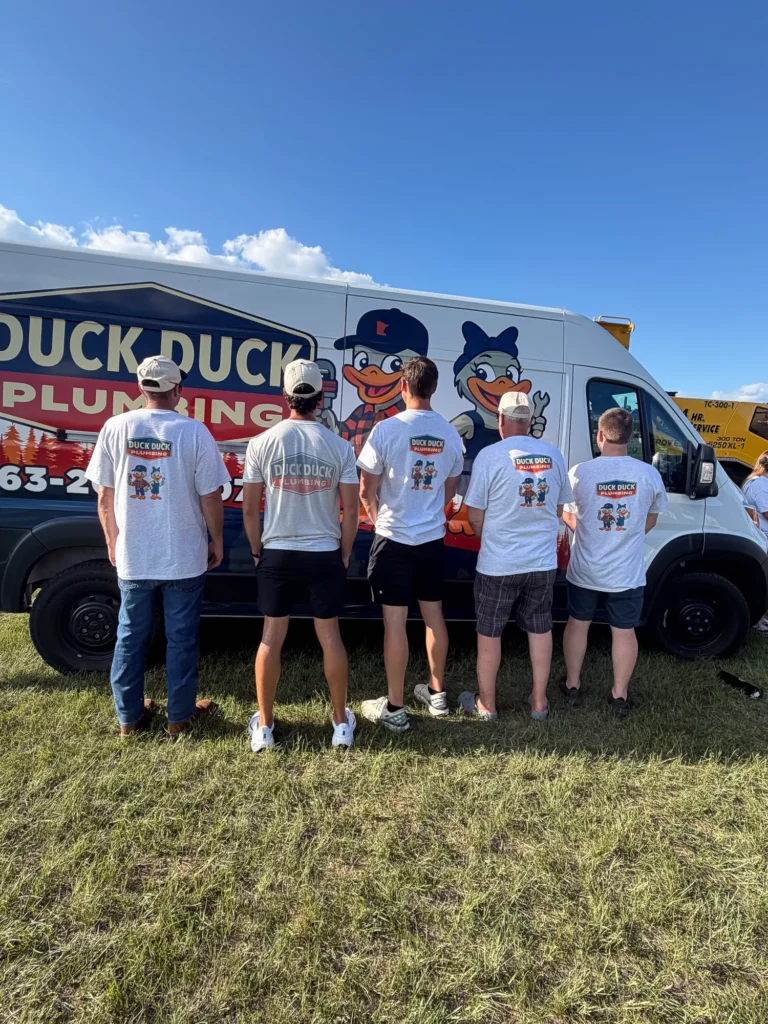 Duck Duck Plumbing shirts in front of the service van